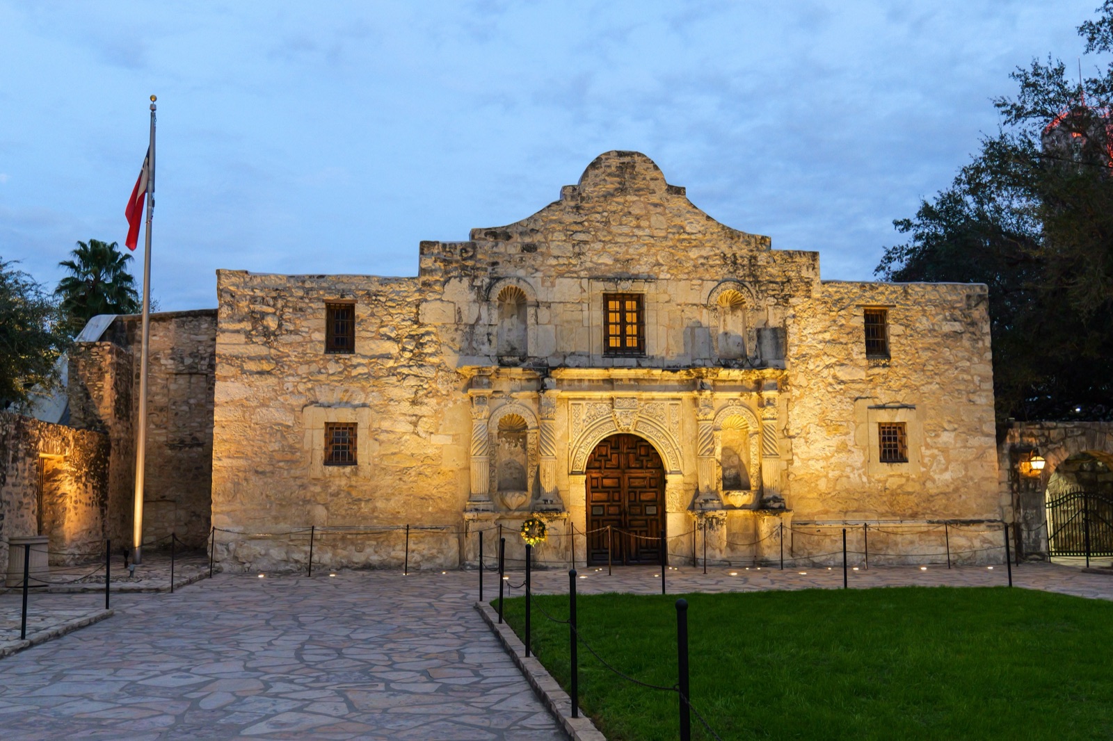 The Alamo facade lit warmly at dusk