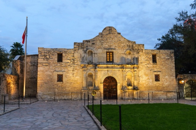 The Alamo facade lit warmly at dusk