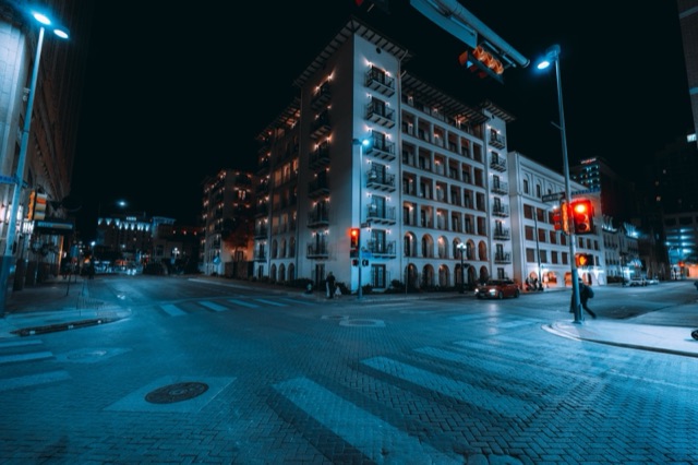 Apartment balconies above a downtown San Antonio street at night
