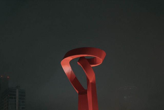 The red Torch of Friendship sculpture against the San Antonio night sky