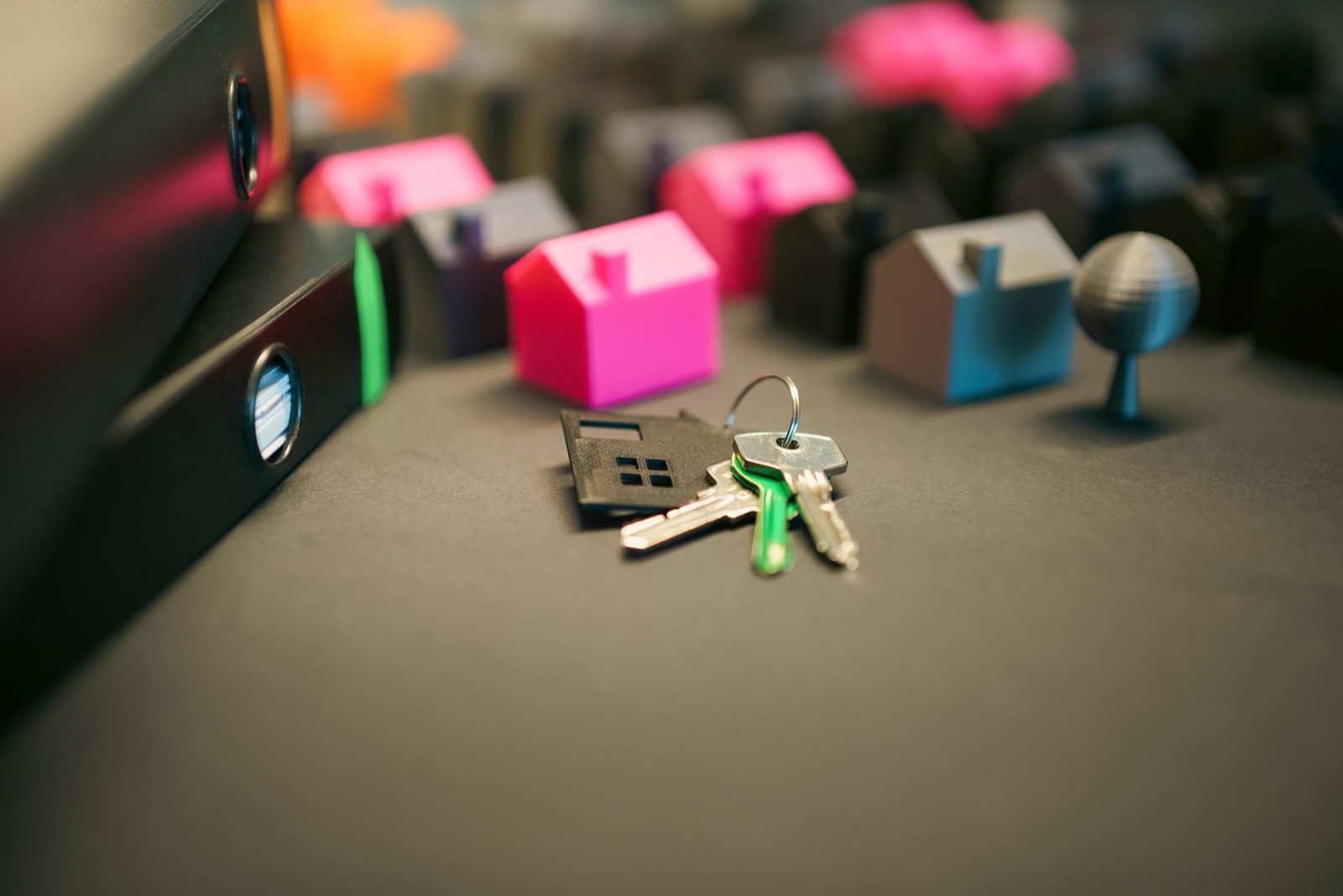Keys and a house-shaped keychain among miniature model houses