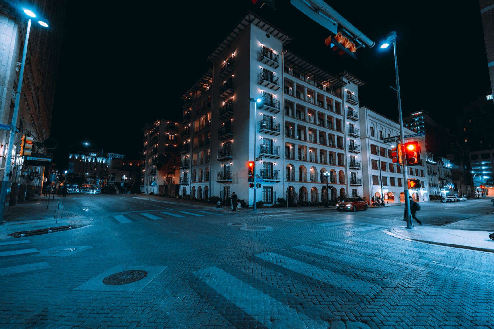 Apartment balconies above a downtown San Antonio street at night